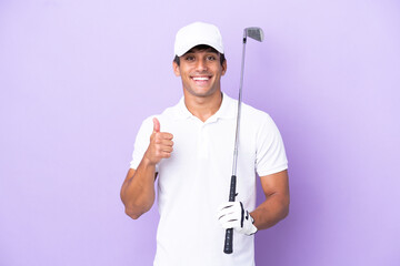 Naklejka premium Young caucasian man isolated on purple background playing golf and with thumbs up because something good has happened