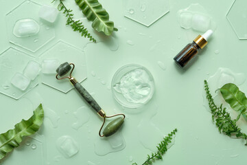 Moisturizer, green jade face roller with exotic fern leaves. Mint green background with moisturizer...