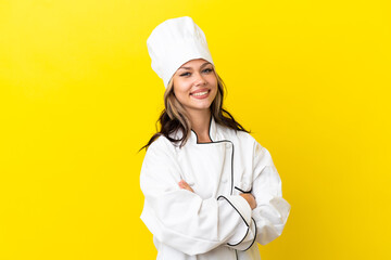 Young Russian chef girl isolated on yellow background with arms crossed and looking forward