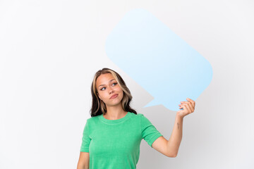 Teenager Russian girl isolated on blue background holding an empty speech bubble