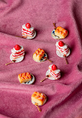 miniature sweet cakes and buns on fabric background
