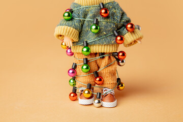 kid doll with tied Christmas lights on it