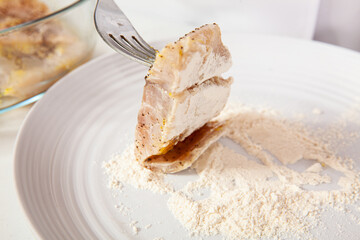 Fish marinade preparation steps: Covering sea bass pieces in flour