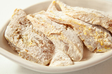 Fish marinade preparation steps: Covering sea bass pieces in flour