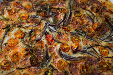 vegan homemade focaccia bread with cherry tomatoes and onions freshly cooked just out of the oven, healthy plant-based food