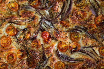 Obraz na płótnie Canvas vegan homemade focaccia bread with cherry tomatoes and onions freshly cooked just out of the oven, healthy plant-based food