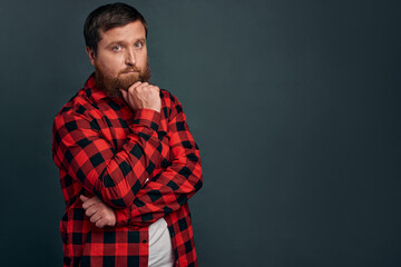 Fototapeta premium Picture of handsome young bearded man standing over gey wall background isolated. Looking camera.