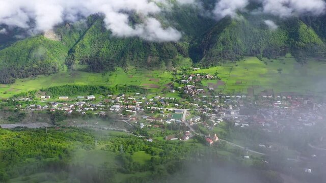 Aerial: Mestia highland town, view through clouds in Caucasus Mountains, Georgia