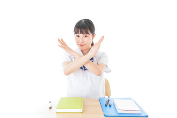 バツを示す制服姿の女子学生