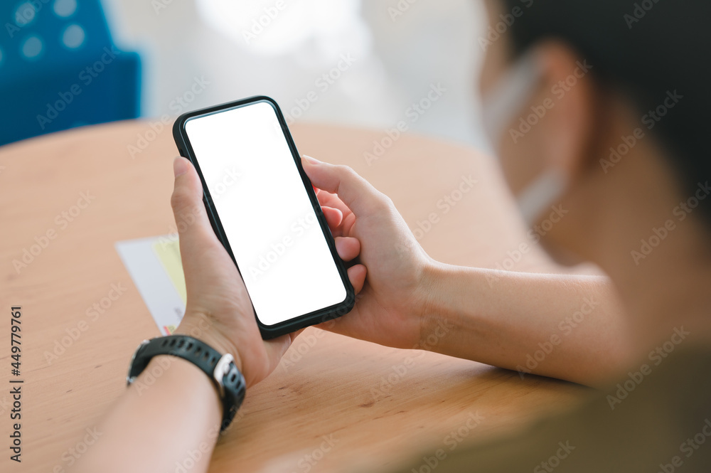 Poster woman's hand holding black mobile phone with blank desktop screen. empty screen for mockup image or 