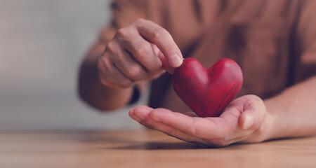Male hands holding red heart, world mental health day and world heart day, Life and health insurance, CSR social responsibility, organ donation, ​concept of love - obrazy, fototapety, plakaty