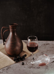 still life georgian jug and wine glasses on linen with a grape on stone background