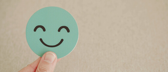 Hand holding green happy smile face paper cut, good feedback rating and positive customer review,...