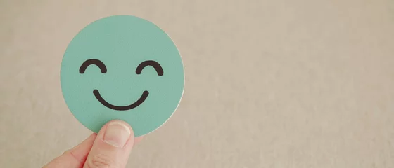 Foto op Plexiglas Hand met groene blije glimlach op papier gesneden, goede feedbackbeoordeling en positieve klantrecensie, ervaring, tevredenheidsonderzoek, beoordeling van de geestelijke gezondheid, concept van werelddag voor geestelijke gezondheid © SewcreamStudio