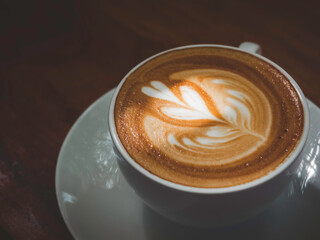 Latte art coffee cup. Close up latte foam texture in cappucino of white hot coffee cup with beautiful light and shadow, top view.