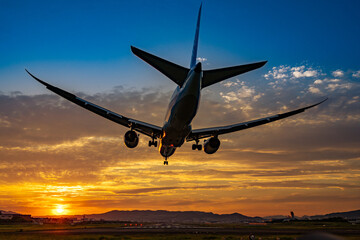 美しい空を背景に着陸する飛行機のシルエット
