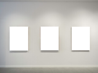 Three mockup white blank museum art frames on white clean wall background with lighting.