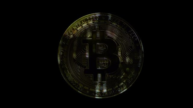 Bitcoin glitters in colorful flares, moving light spots, beautiful images on a black background. Closeup. Macro