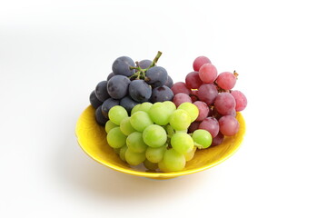 皿に盛られた小さな房の3種類のブドウ