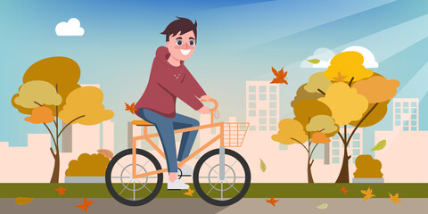 Young happy man ride a bicycle in the autumn.