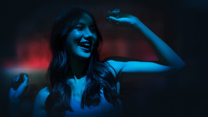 Obraz na płótnie Canvas woman having fun dancing at night disco club