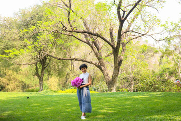 Asian woman holding bouquets  in garden.