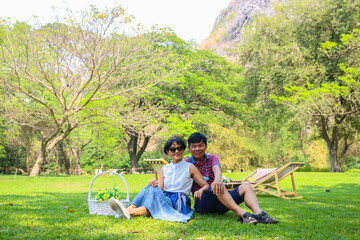 Happy senior couple relaxing in green park.