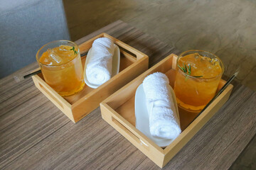 Welcome drink and cold towel on wooden tray for two people in luxury hotel