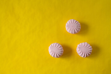 yellow background. pink marshmallows on the table