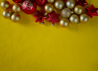 yellow background, christmas toys, yellow balls, red stars. for congratulations.