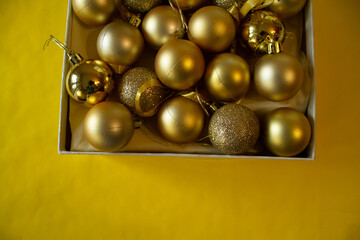 yellow background, a box with yellow Christmas balls for the Christmas tree