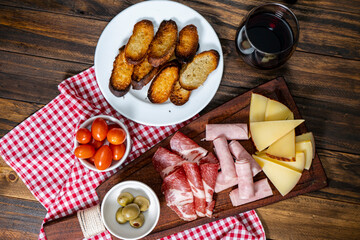 Fototapeta na wymiar Cheese and cold cuts table, cherry tomatoes, olives. Bird eye view.