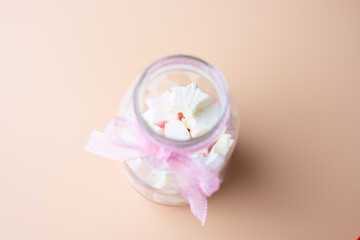 a jar of marhmallows against blurry background. 