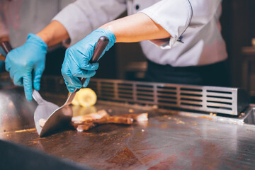 Hand of man take cooking of meat with vegetable grill, Chef cooking wagyu beef in Japanese teppanyaki restaurant