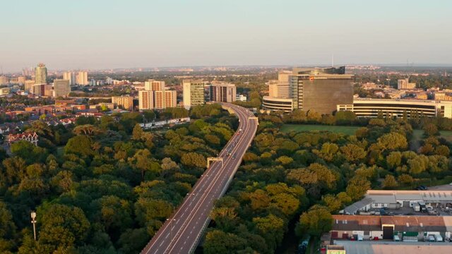 Cinematic drone shot over highway going into built up London Brentford at sunset