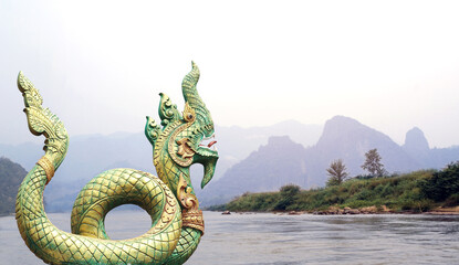 Statue of mythical asian naga snake and landscape with mountains and river Mekong - obrazy, fototapety, plakaty