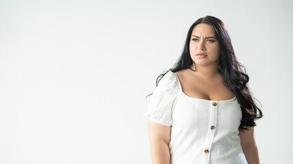 Body shaming. Upset woman. Social blaming. Psychology pressure. Advertising background. Sad worried plus size lady looking forward hesitating to go isolated white copy space.