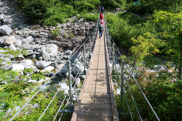 Fototapeta na wymiar 北アルプスの上高地から涸沢までにある橋を渡る登山者