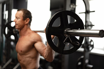 Obraz na płótnie Canvas Senior man working out at the gym doing squats