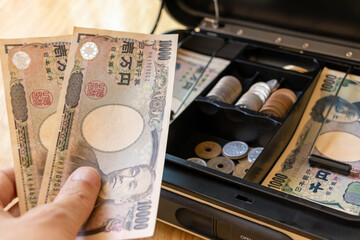 金庫の中から現金を取り出す