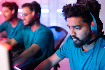 Head shot of gamer talking on headphones while playing live streaming game or esports tournament - concept of professional gamers at league competition. © WESTOCK