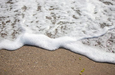 White foamy wave over sand beach