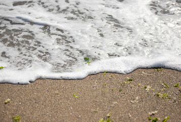 White foamy wave over sand beach
