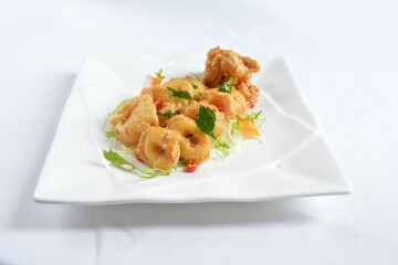 wok fried seafood octopus in pumpkin salted egg yolk sauce seafood in white background asian halal menu
