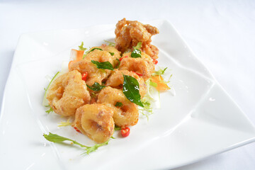 wok fried seafood octopus in pumpkin salted egg yolk sauce seafood in white background asian halal menu