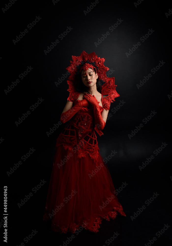 Wall mural portrait of beautiful young asian woman wearing red corset, posing in gothic horror style with creative hand gestures isolated against  studio background. - Wall murals