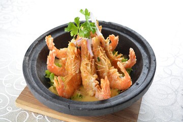 deep fried crispy big fresh tiger prawn in spicy chilli curry sauce in hot clay pot in white background asian halal menu