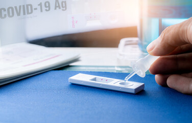 Hand holding sample tube and drops in the test device of covid 19 antigen self-test. Antigen test kit for detection of coronavirus infection. Rapid antigen test. Coronavirus diagnosis. Medical device.