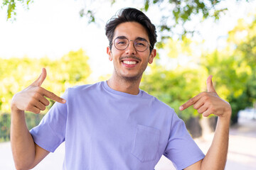 Young caucasian man at outdoors in a park proud and self-satisfied