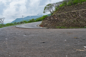 Curva muy cerrada donde pasan los vehículos con mucha precaución y rodea una montaña